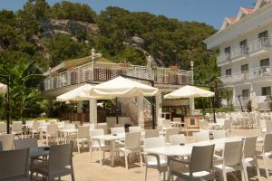 Un restaurante con mesas, sillas y sombrillas. en Mir'Amor Hotel -All Inclusive Plus, en Antalya