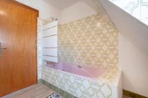 a bathroom with a pink bath tub on the wall at Les Hortensias Entre Terre Et Mer in Plogoff +21 photos