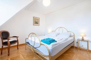 a bedroom with a bed and a chair at Les Hortensias Entre Terre Et Mer in Plogoff
