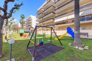 a playground in a park next to a building at Apartamentos VENTURA PARK-6 in Salou