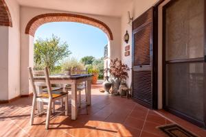 a dining room with an archway and a table and chairs at Vallerana Appartamenti in La Capriola