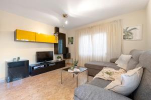 a living room with a couch and a tv at Apartamento VIKING in La Pineda