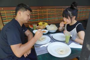 Ein Mann und eine Frau sitzen an einem Tisch und essen in der Unterkunft Green Earth Resort in Dambulla + 43 Fotos