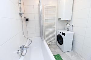 a bathroom with a washing machine and a washer at Ferienwohnung Zirbitzblick in Fohnsdorf