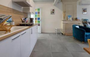 a kitchen with white cabinets and a blue chair at 1 Bedroom Cozy Home In La-Gripperie-Saint-Sym in La-Gripperie-Saint-Symphorien