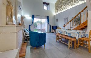 a dining room with a table and a blue chair at 1 Bedroom Cozy Home In La-Gripperie-Saint-Sym in La-Gripperie-Saint-Symphorien
