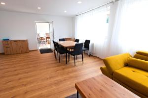 a living room with a yellow couch and a table and chairs at Ferienwohnung Zirbitzblick in Fohnsdorf