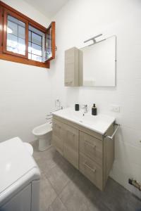 a bathroom with a sink and a toilet and a mirror at Flat Number 11 in Milan