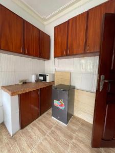 Una cocina con gabinetes de madera y refrigerador. en The soft stay, en Namugongo