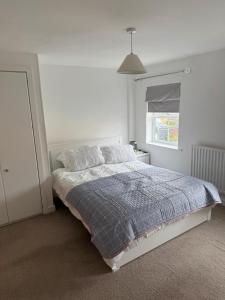 a white bedroom with a bed and a window at Modern 3-Bedroom Home 3 Minutes from Biggin Hill Airport - Secure Gated Community in Biggin Hill