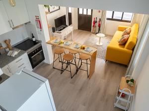 a small kitchen and living room with a yellow couch at Traditional Madeira House Garden, Terrace & BBQ in Ribeira Brava