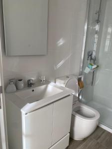 a white bathroom with a toilet and a sink at Casa do João e da Teresa in Ribeira Brava +35 photos