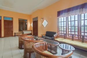 a living room with chairs and a couch at RedDoorz near Taman Wisata New Balekambang Tawangmangu in Karanganyar