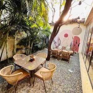 Un patio con una mesa y sillas y un árbol. en Serene Fields Retreat, en Kanāria