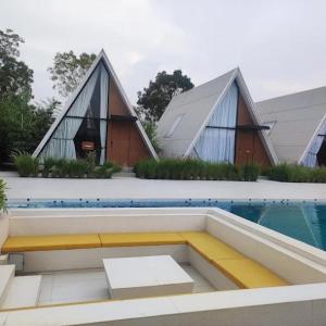 una piscina con dos cabañas y una piscina en Serene Fields Retreat, en Kanāria