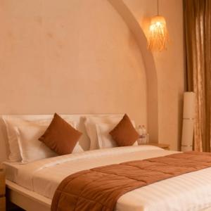 Un dormitorio con una cama con sábanas y almohadas blancas. en Serene Fields Retreat, en Kanāria