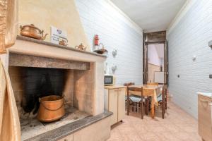 a kitchen with a brick fireplace and a dining room at Meraviglie Salentine - Lecce in Lequile