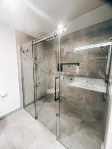a bathroom with a shower and a sink at Modern Coastal Retreat in Pyes Pa in Tauranga +7 photos