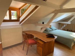 a bedroom with a bed and a wooden desk at Petite maison SOUS LE TILLEUL in Schiltigheim