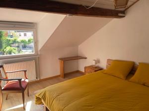 a bedroom with a yellow bed and a window at Petite maison SOUS LE TILLEUL in Schiltigheim +6 photos