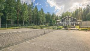 un campo da tennis con rete di fronte a un edificio di Hideout Villa Swan a Säräisniemi