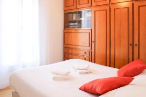 a bedroom with a bed with red pillows and a cabinet at Renovated 2-bedroom apartment in Drancy +12 photos