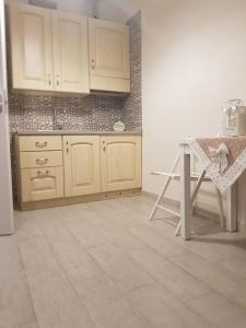 a kitchen with white cabinets and a table in it at dimore cieli di dante in Conversano