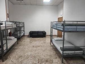 Cette chambre comprend 4 lits superposés et un canapé. dans l'établissement Hostel M Torres, à Madrid