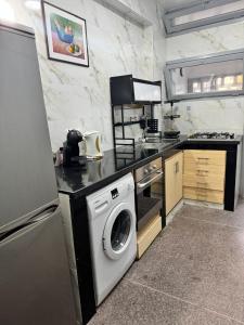 a kitchen with a washing machine and a washer at Appartement Rabat Agdal in Oulad Akkou +6 photos