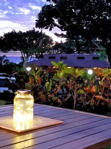 un pot sur une table en bois avec une lumière dessus dans l'établissement Steps to the Beach and 5-Min Walk to bites and bars, à Kihei