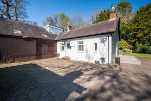 Casa blanca con garaje y entrada en The Stables Cottage, Beattock, Moffat, en Beattock