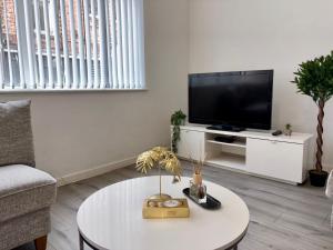 a living room with a tv and a coffee table at AA Newcastle Apartments in Newcastle upon Tyne +6 photos