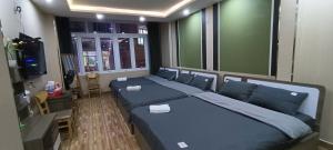 a bedroom with two beds and a television in it at ROSE HOSTEL DALAT in Da Lat