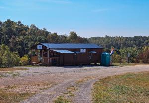 a building with a dirt road in front of a field at The Hocking Hills Store Campsite #2 in Logan