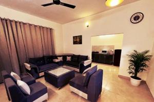 Una sala de estar con sofás y un ventilador de techo. en Embassy Loagde Inn, en Mussoorie