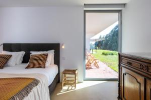 a bedroom with a bed and a sliding glass door at Casa do Regadio in Zambujeira do Mar +65 photos