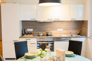 una cocina con armarios blancos y una mesa con flores en Design-Apartment -Garten -Parken, en Böblingen