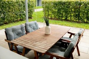 una mesa de madera con sillas y un jarrón. en Design-Apartment -Garten -Parken, en Böblingen