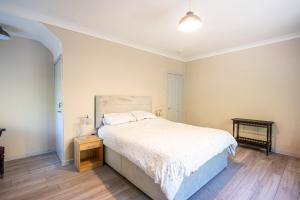 Un dormitorio con una cama grande y una mesita de noche. en The Stables Cottage, Beattock, Moffat, en Beattock
