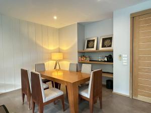 a dining room with a wooden table and chairs at Heart of Khao Yai Villa in Mu Si