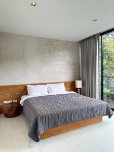 a bedroom with a large bed and a large window at Heart of Khao Yai Villa in Mu Si +12 photos