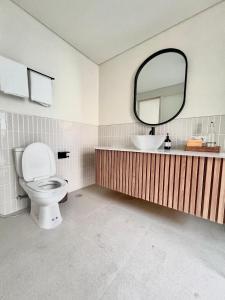 Un baño con inodoro, lavabo y espejo. en 2 bedroom Sofira villa, en Nusa Dua