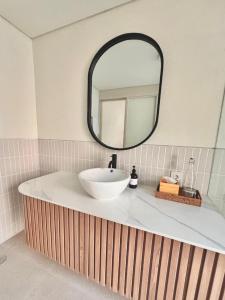 Un baño con un lavabo blanco y un espejo. en 2 bedroom Sofira villa, en Nusa Dua