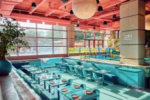 a dining room with blue tables and chairs at Walk to UT and E 6th in ATX House and Free Swim Club by Austin Vacay in Austin