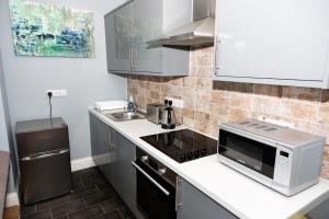 a kitchen with a microwave and a sink at Bewick Apartments in Newcastle upon Tyne