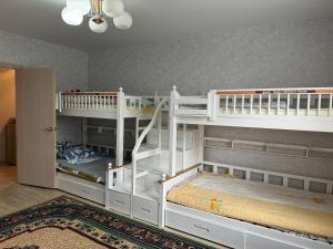 1 Schlafzimmer mit 2 Etagenbetten und einer Treppe in der Unterkunft 3х комнатная квартира in Öskemen