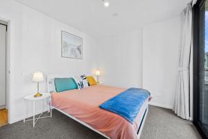 une chambre blanche avec un lit et une fenêtre dans l'établissement Stylish Dickson 1BR Perfect for Business and Leisure, à Downer