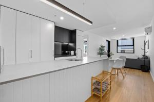 une cuisine blanche avec un évier et un comptoir dans l'établissement Stylish Dickson 1BR Perfect for Business and Leisure, à Downer