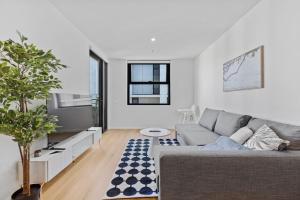 un salon avec un canapé et une télévision dans l'établissement Stylish Dickson 1BR Perfect for Business and Leisure, à Downer