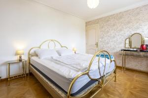 a bedroom with a white bed with a metal frame at Chambre Les Hortensias in Plogoff